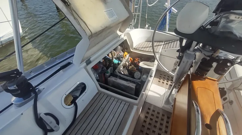 Slide: The Image of Beneteau Oceanis 390 cockpit storage area with open hatch, showcasing organized equipment. - 38