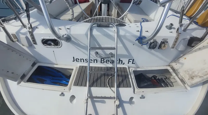 Slide: The Image of Beneteau Oceanis 390 sailboat stern with ladder, storage compartments, and Jensen Beach, FL inscription. - 40