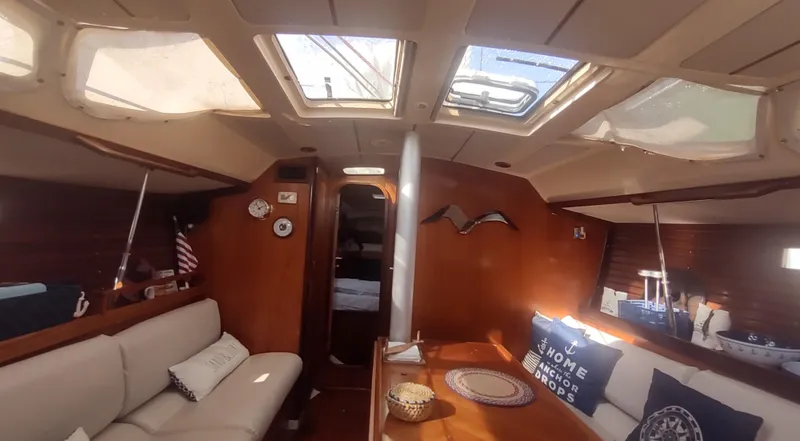 Slide: The Image of Interior of 1990 Beneteau Oceanis 390 sailboat with cozy seating and nautical decor. - 6