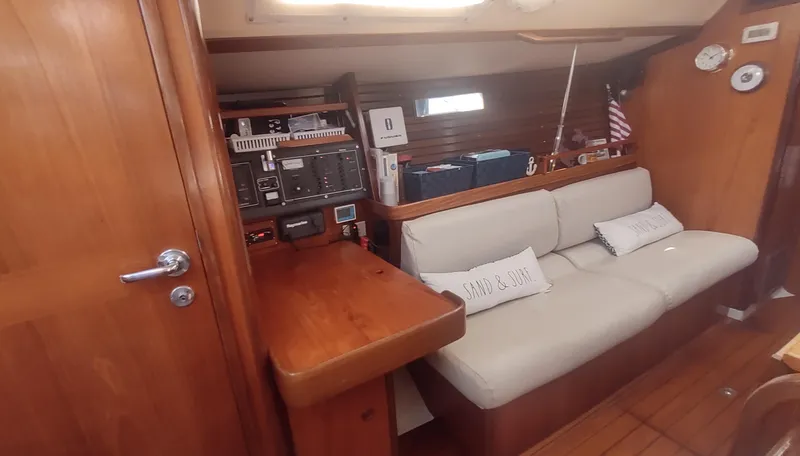 Slide: The Image of Interior of 1990 Beneteau Oceanis 390 sailboat with wooden finish and cozy seating area. - 9