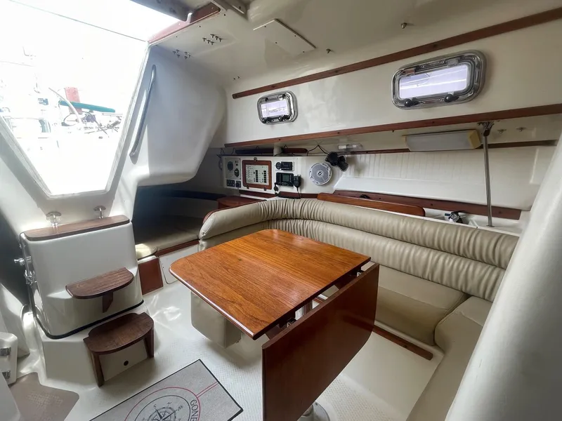 Slide: The Image of 2005 Hake Seaward 32RK yacht interior with wooden table, cushioned seating, and navigation equipment. - 16