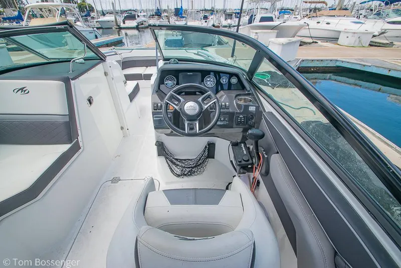 Slide: The Image of 2018 Monterey MX6 Surf Edition boat interior with steering wheel and dashboard at marina. - 10