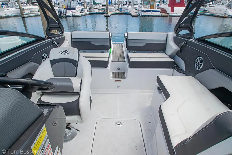 Slide: The Image of 2018 Monterey MX6 Surf Edition boat interior with seating, steering, and marina view. - 17