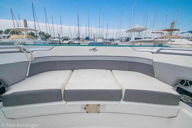 Slide: The Image of 2018 Monterey MX6 Surf Edition boat interior with cushioned seating at marina. - 22