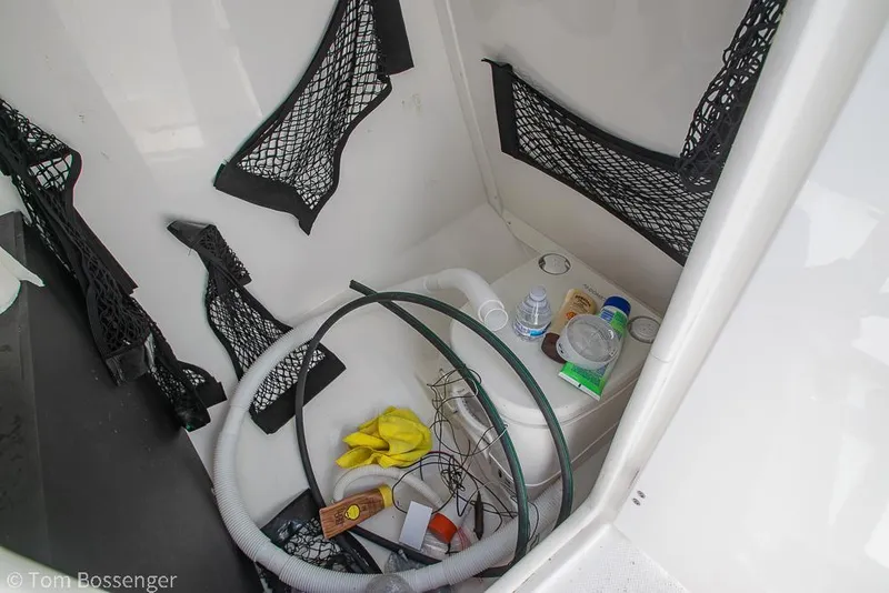 Slide: The Image of Storage compartment in 2018 Monterey MX6 Surf Edition boat with various items and netting. - 29