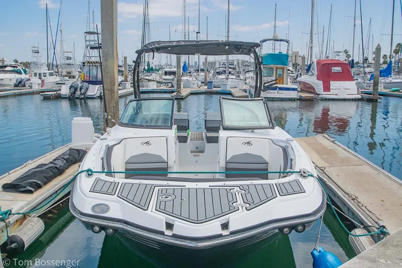 Slide: The Image of 2018 Monterey MX6 Surf Edition boat docked in a marina with sailboats. - 4