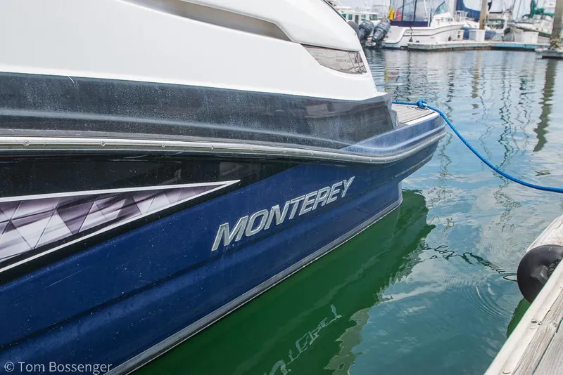 Slide: The Image of 2018 Monterey MX6 Surf Edition boat docked in marina, blue hull, calm water. - 5
