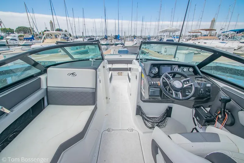 Slide: The Image of 2018 Monterey MX6 Surf Edition boat interior at marina, featuring steering wheel and seating. - 9