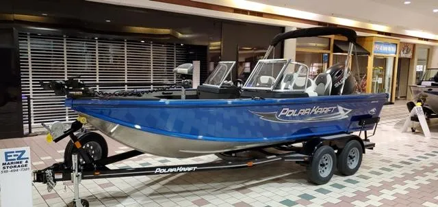 Slide: The Image of 2023 Polar Kraft Kodiak Sport 185 FS boat displayed indoors on a trailer. - 1