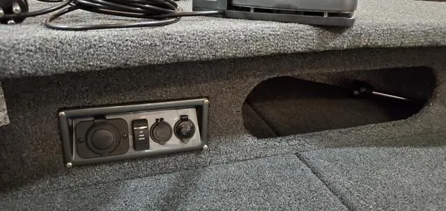 Slide: The Image of 2023 Polar Kraft Kodiak Sport 185 FS boat interior with power outlets and storage compartment. - 15