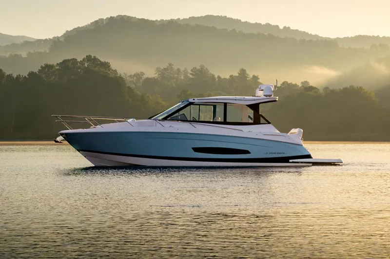 The Image of 2026 Regal 36 Grande Coupe boat displayed indoors, blue and white design, showroom setting. - 1