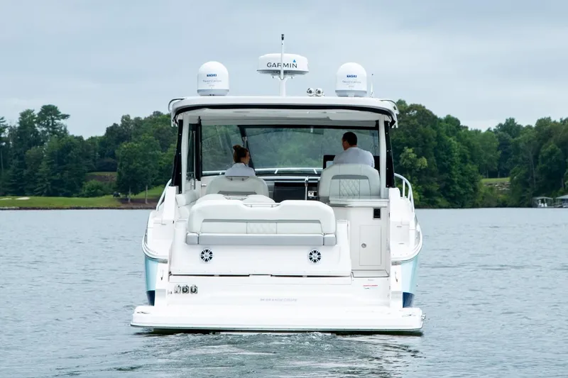 Slide: The Image of 2026 Regal 36 Grande Coupe boat displayed indoors with colorful life jackets on racks. - 6