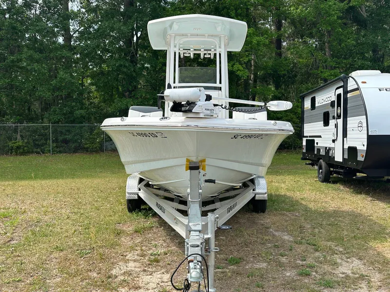 Slide: The Image of 2023 Robalo 226 Cayman boat on trailer, parked outdoors near RV. - 2