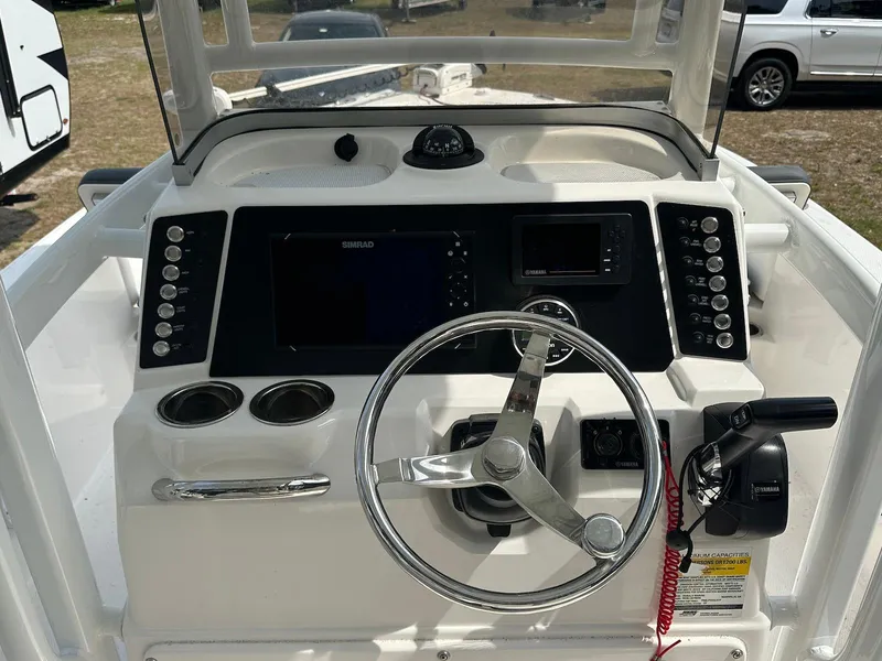 Slide: The Image of 2023 Robalo 226 Cayman boat dashboard with steering wheel and control panel. - 5