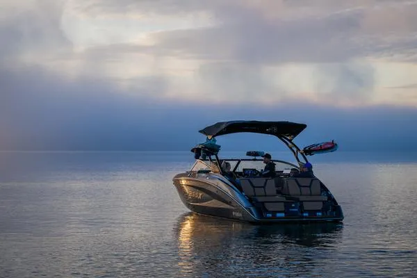 Slide: The Image of 2025 Yamaha Boats 255XD on calm water at sunset. - 10