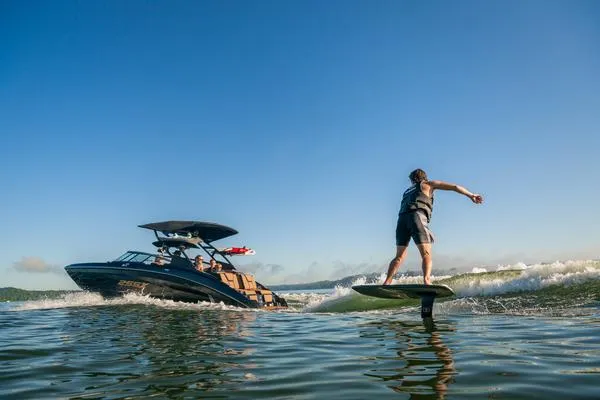Slide: The Image of 2025 Yamaha Boats 255XD towing a wakeboarder on a sunny day. - 7