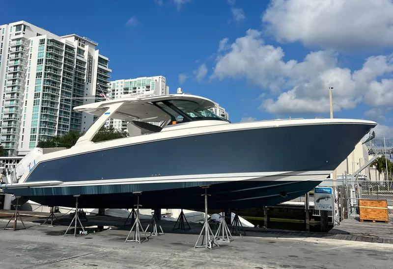 The Image of 2023 Tiara Yachts 38 LS boat on display, with modern buildings and blue sky background. - 0