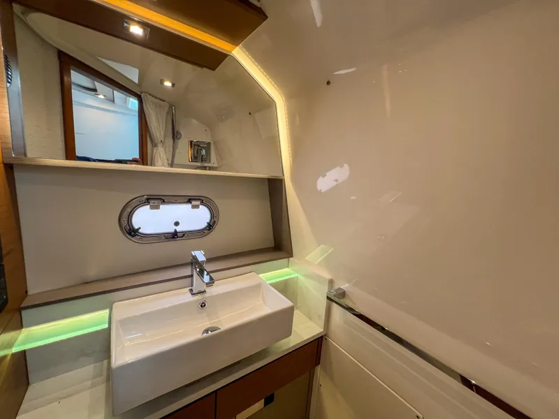 Slide: The Image of 2023 Tiara Yachts 38 LS bathroom with modern sink and porthole window. - 12