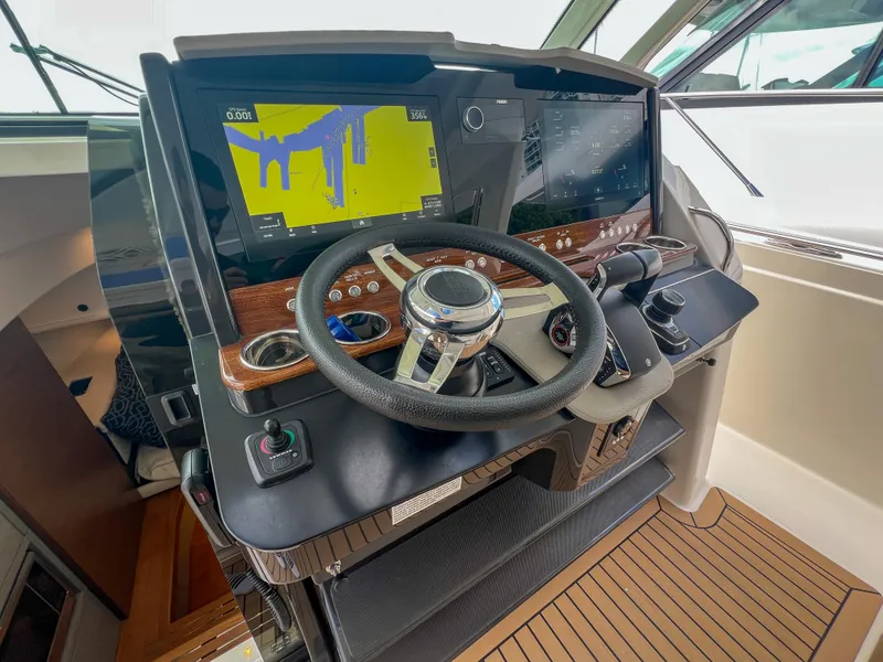 Slide: The Image of 2023 Tiara Yachts 38 LS helm with advanced navigation displays and steering wheel. - 14