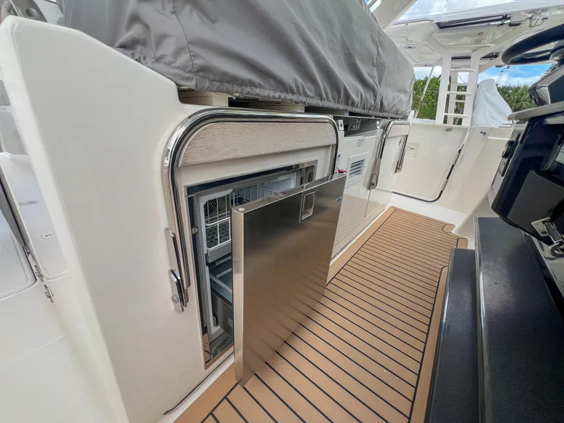 Slide: The Image of 2023 Tiara Yachts 38 LS interior with open stainless steel drawer on teak flooring. - 16