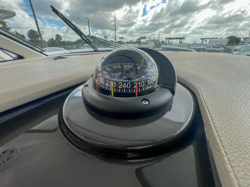 Slide: The Image of Compass on 2023 Tiara Yachts 38 LS dashboard under cloudy sky. - 17