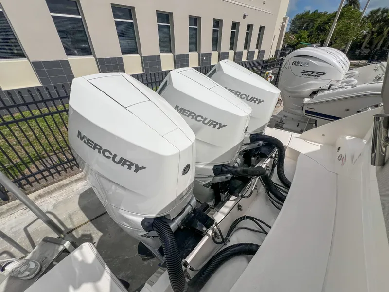 Slide: The Image of 2023 Tiara Yachts 38 LS with triple Mercury outboard engines, docked outdoors. - 26