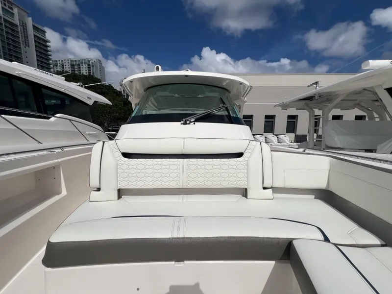 Slide: The Image of 2023 Tiara Yachts 38 LS boat interior with white seating under a blue sky. - 8