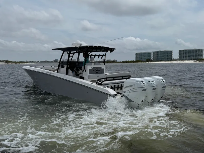 Slide: The Image of 2022 Fountain 38TE boat with triple Mercury engines cruising on water, cityscape in background. - 11