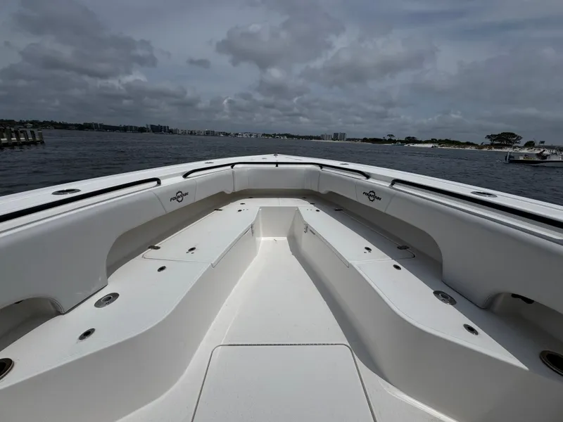 Slide: The Image of 2022 Fountain 38TE boat interior with spacious seating, on a cloudy day by the water. - 19