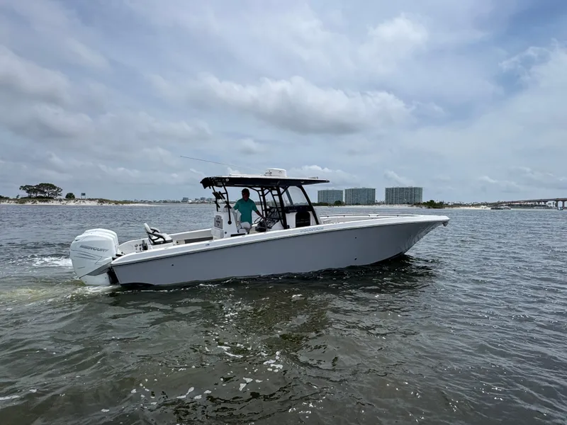 Slide: The Image of 2022 Fountain 38TE boat cruising on a calm waterway under a cloudy sky. - 3