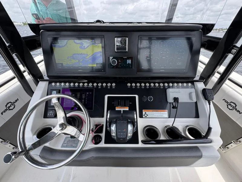 Slide: The Image of Control panel of a 2022 Fountain 38TE boat with navigation screens and steering wheel. - 30