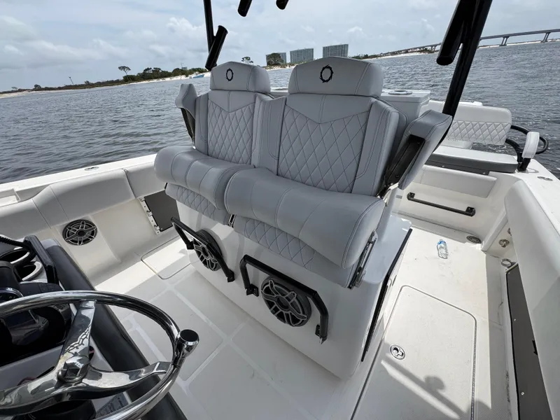 Slide: The Image of 2022 Fountain 38TE boat interior with luxury seating and steering wheel, on calm water. - 32