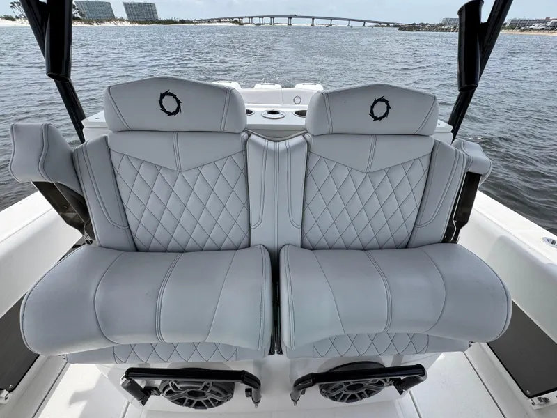 Slide: The Image of Luxury seating on 2022 Fountain 38TE boat with quilted design, overlooking water and bridge. - 33