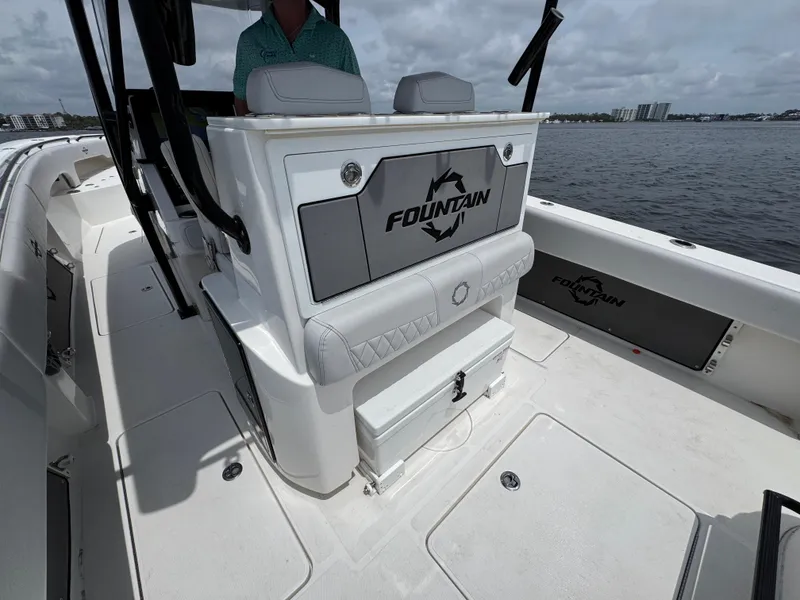 Slide: The Image of 2022 Fountain 38TE boat interior with seating and storage, on a calm water backdrop. - 34