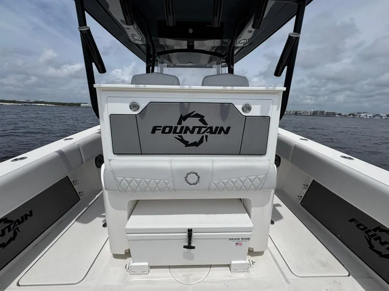 Slide: The Image of 2022 Fountain 38TE boat interior with branded seating and storage, on a calm water backdrop. - 35