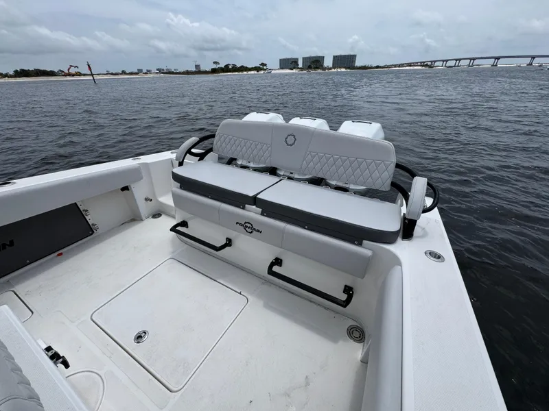 Slide: The Image of 2022 Fountain 38TE boat interior with seating, on calm water near a bridge. - 37