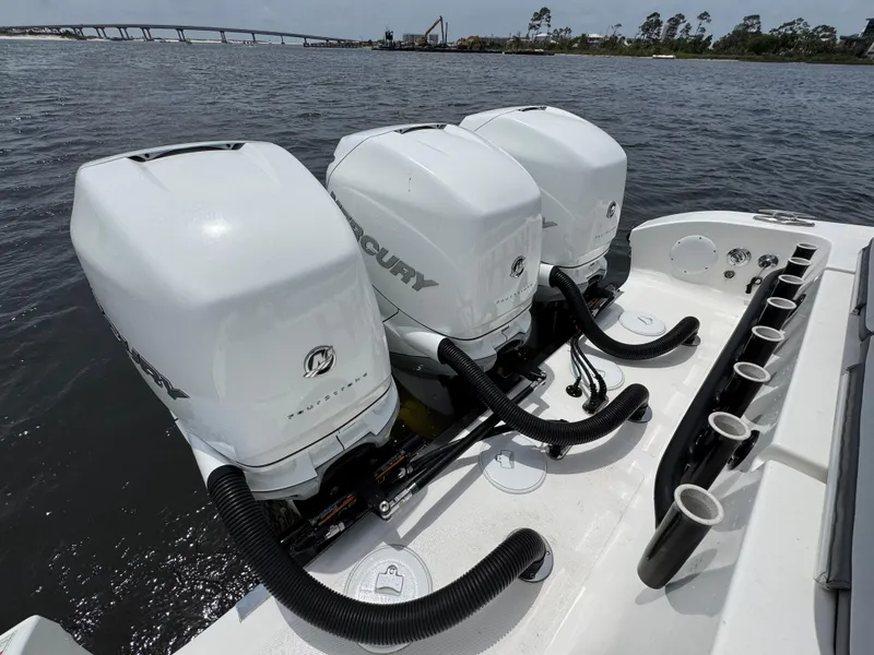 Slide: The Image of Triple Mercury outboard engines on a 2022 Fountain 38TE boat, docked near a bridge. - 41