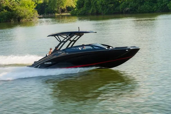 Slide: The Image of 2025 Yamaha Boats 275 SD cruising on a serene lake with lush green surroundings. - 10