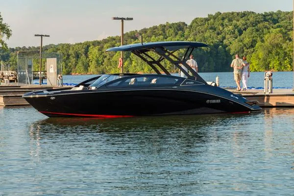 Slide: The Image of 2025 Yamaha Boats 275 SD in a serene lake setting, docked with lush greenery background. - 4
