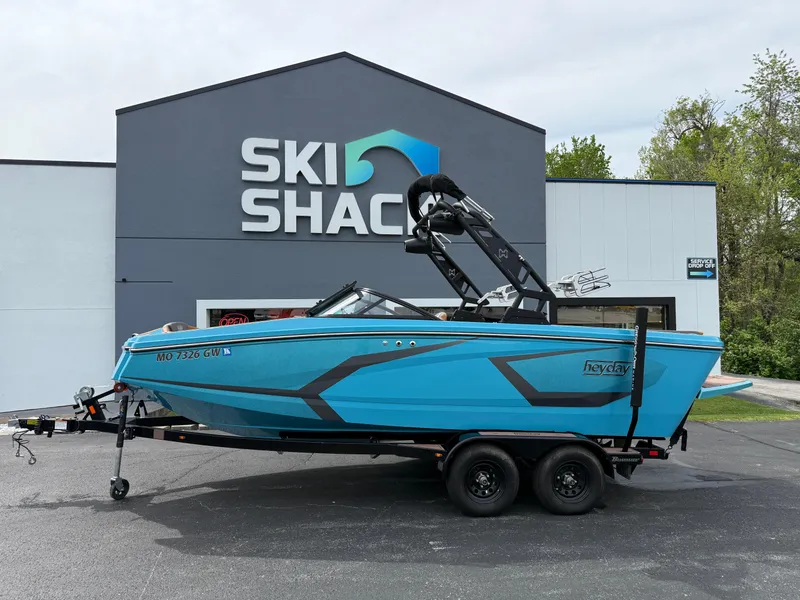 Slide: The Image of 2022 Heyday WT-2DC boat in blue, parked outside Ski Shack building. - 0