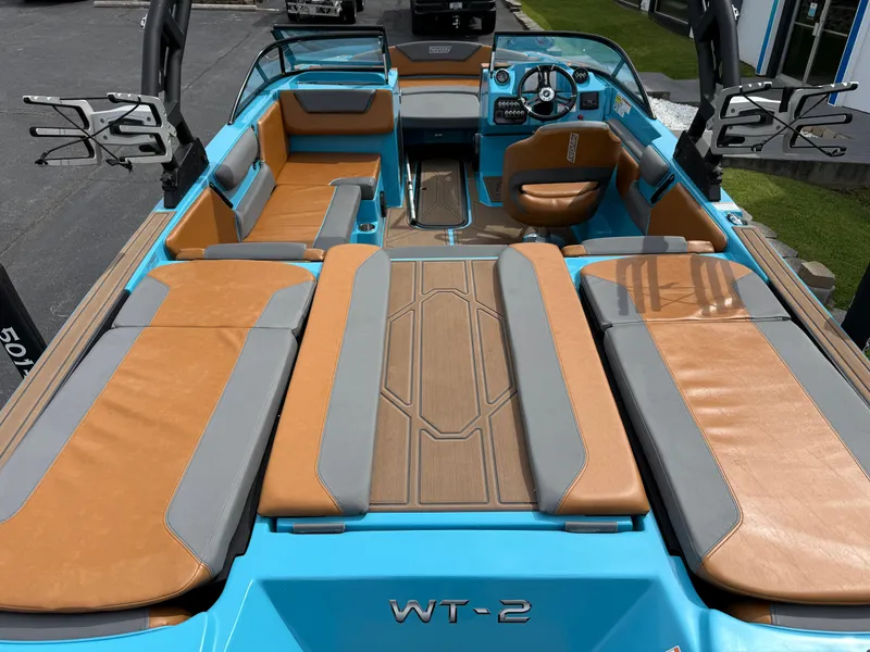Slide: The Image of 2022 Heyday WT-2DC boat interior with tan and gray seating, blue accents, and steering console. - 12