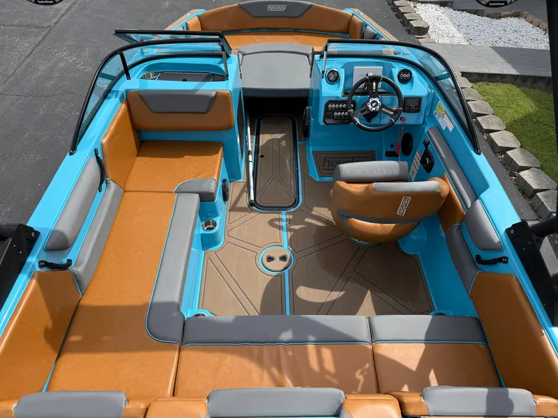 Slide: The Image of 2022 Heyday WT-2DC boat interior with tan and blue seating, modern dashboard, and steering wheel. - 15