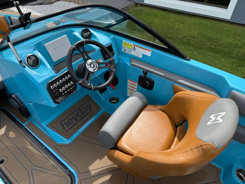 Slide: The Image of 2022 Heyday WT-2DC boat interior with blue dashboard and tan seating. - 17