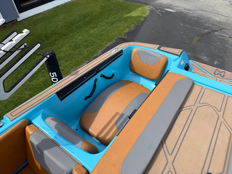 Slide: The Image of 2022 Heyday WT-2DC boat interior with blue and tan seating, docked on grass. - 24