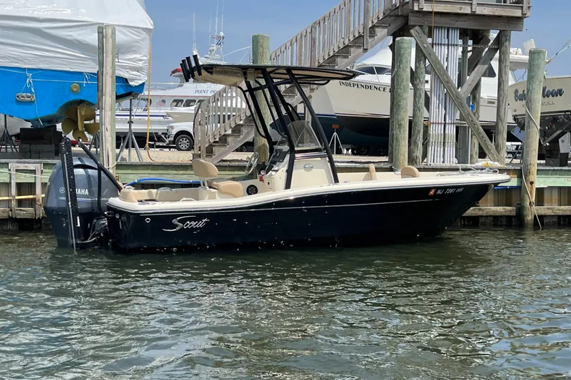Slide: The Image of 2022 Scout 195 Sportfish boat docked at marina, featuring sleek design and Yamaha outboard motor. - 0