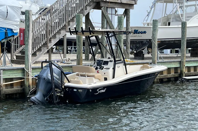 Slide: The Image of 2022 Scout 195 Sportfish boat docked at marina with Yamaha outboard motor. - 1