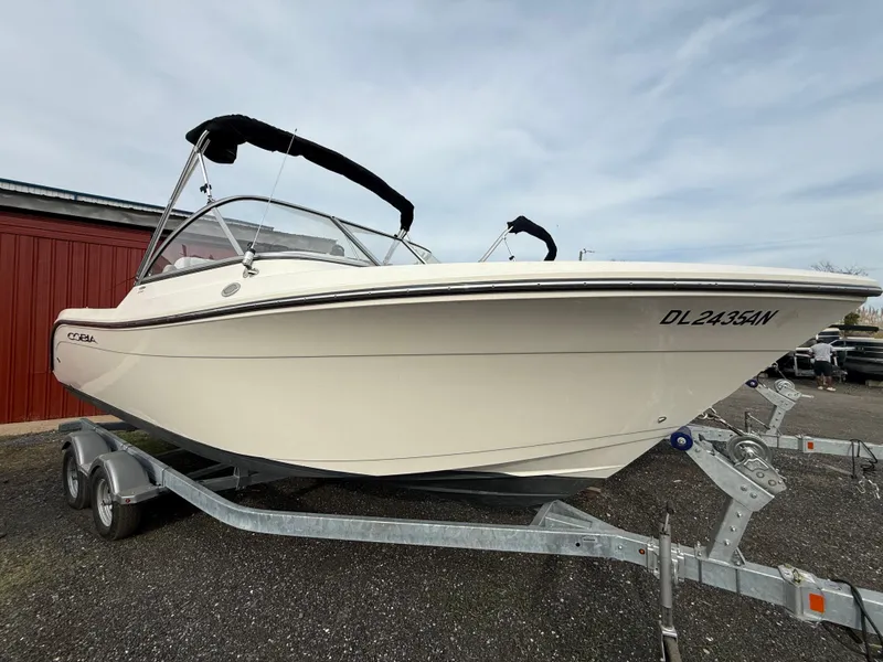 Slide: The Image of 2021 Cobia 220 Dual Console boat on trailer, parked outdoors. - 0