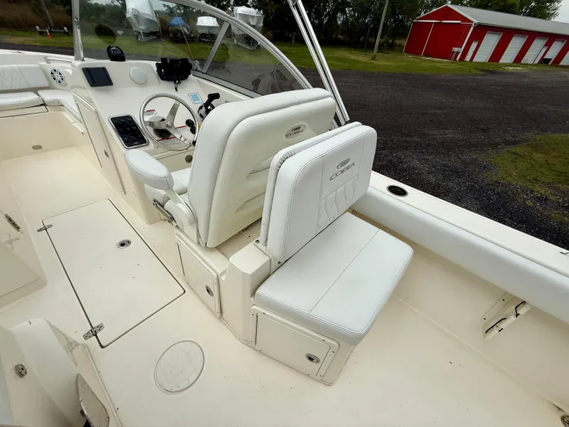 Slide: The Image of 2021 Cobia 220 Dual Console boat interior with white seating and dashboard. - 10