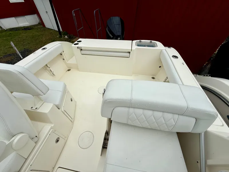 Slide: The Image of 2021 Cobia 220 Dual Console boat interior with white seating and spacious layout. - 11
