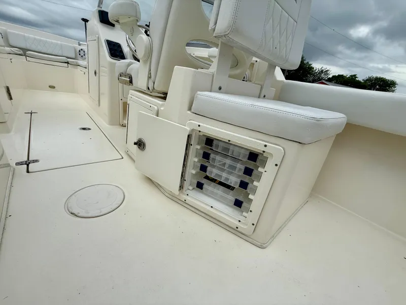 Slide: The Image of 2021 Cobia 220 Dual Console boat interior with white seating and storage compartments. - 12